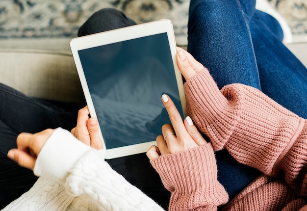 Frauen, die zusammen ein digitales Tablet benutzen