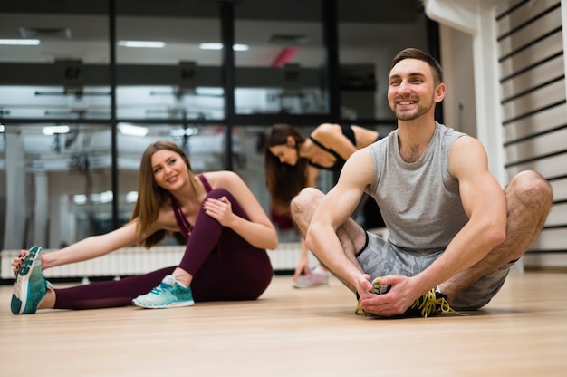 Frauen, die zusammen mit Trainer ausdehnen