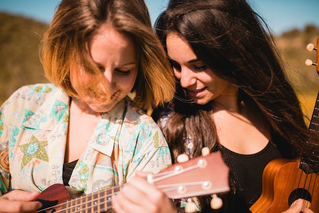 Kostenloses Foto frauen, die zusammen ukulelen spielen