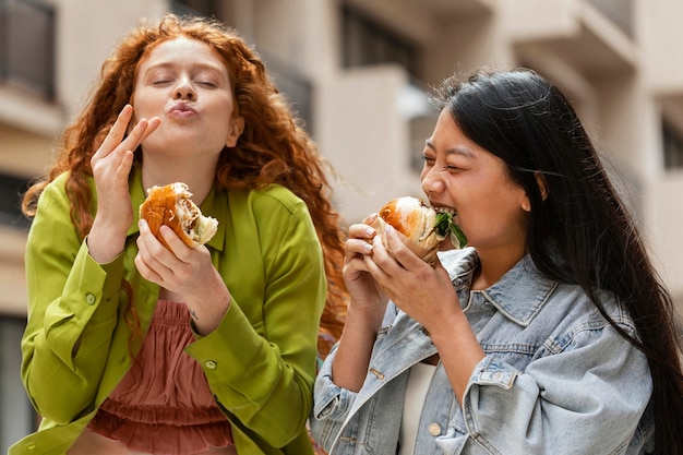 Kostenloses Foto frauen essen draußen leckere burger