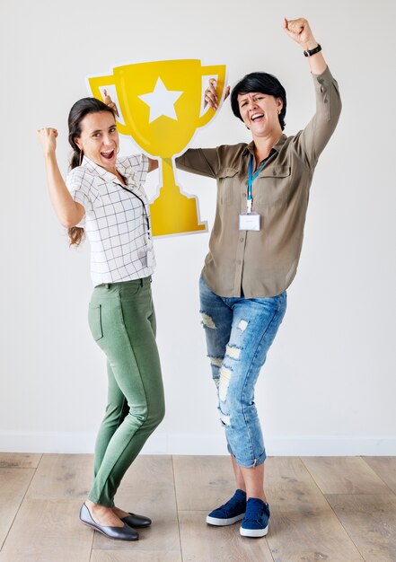 Frauen feiern ihren Erfolg mit einer Trophäe