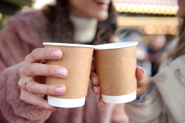 Frauen halten zwei Tassen mit Glühwein