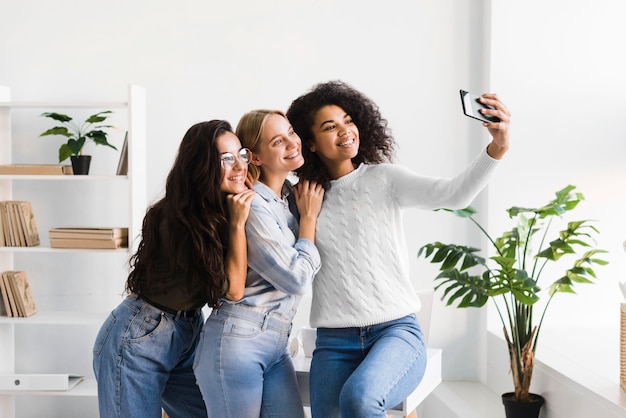 Frauen im Büro machen Selfies