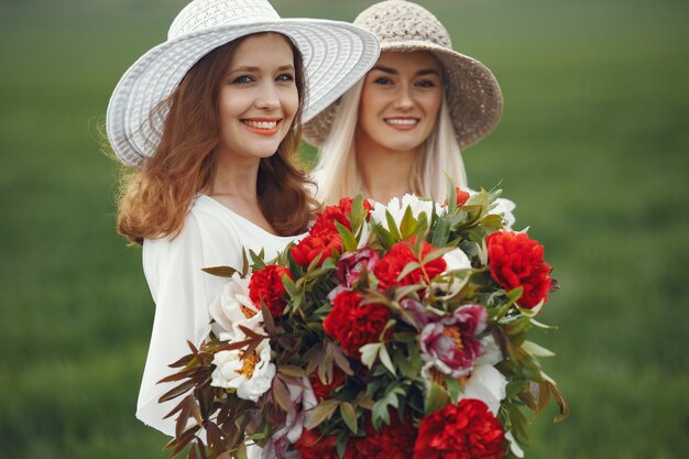 Frauen im eleganten Kleid stehen in einem Sommerfeld