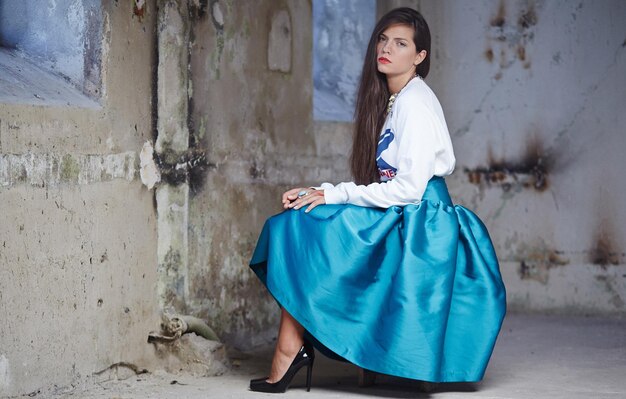 Frauen in blauem Rock und weißer Jacke posieren vor der Kamera.