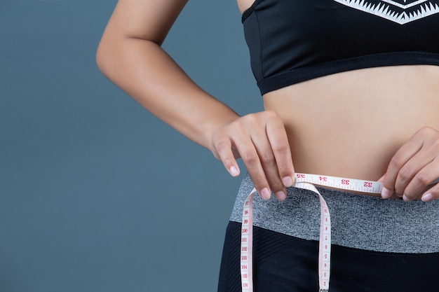 Frauen in Sportbekleidung halten eine Taille.