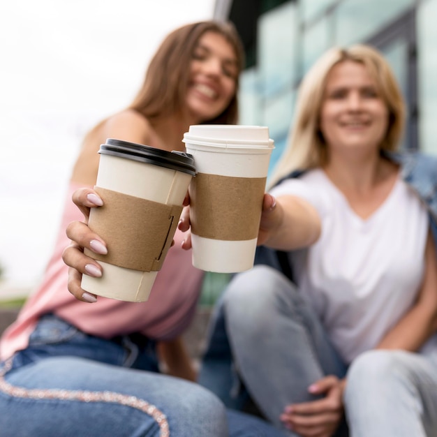 Frauen jubeln mit ihren Tassen Kaffee