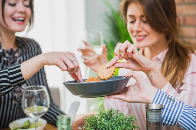 Frauen lachen und essen Kekse