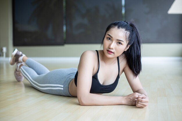 Frauen legen sich hin, entspannen sich und heben ihre Beine im Fitnessstudio.