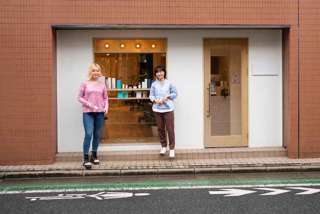 Frauen machen das Schaufenster eines japanischen Friseurs fertig