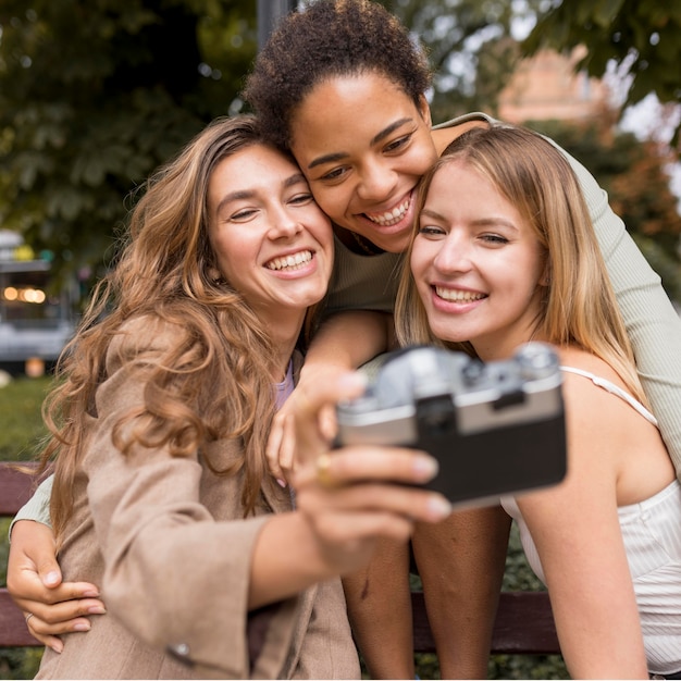 Frauen machen ein Selfie mit einer Retro-Kamera