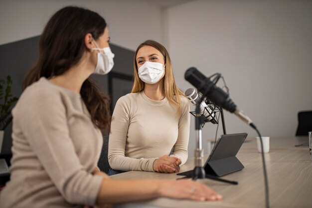 Frauen machen Radio mit medizinischen Masken an