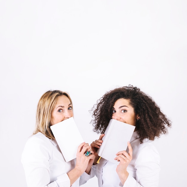 Frauen mit Büchern, die Kamera betrachten