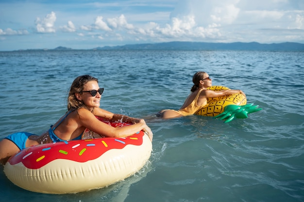 Frauen mit bunten Schwimmern mittlerer Schuss