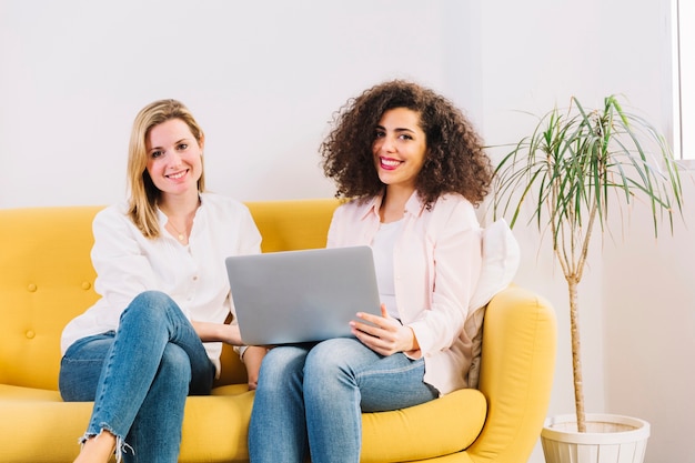 Frauen mit dem Laptop, der Kamera betrachtet