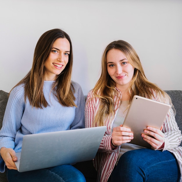 Frauen mit den Technologien, die Kamera betrachten