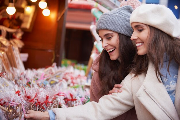 Frauen mit großer Auswahl an Süßigkeiten auf dem Weihnachtsmarkt