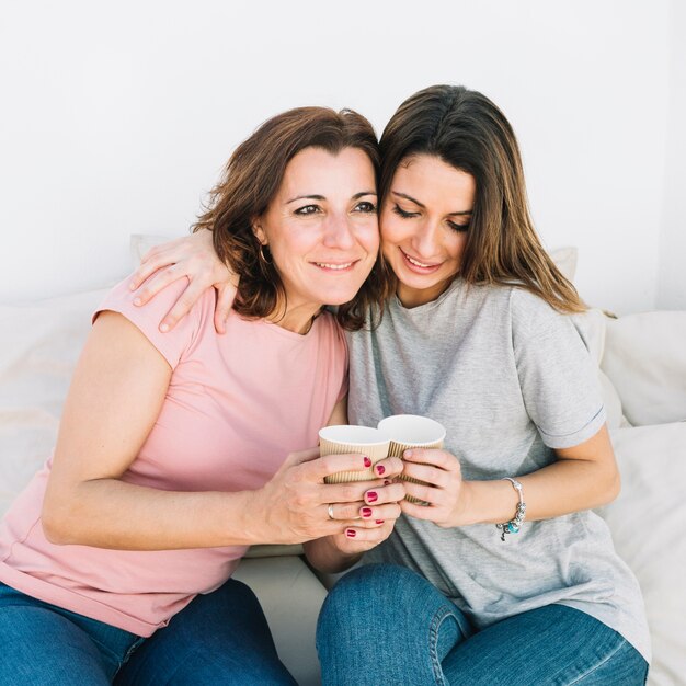 Frauen mit heißen Getränken auf dem Sofa