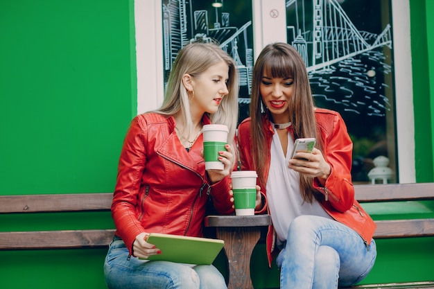 Frauen mit Kaffeetassen eine mobile Suche