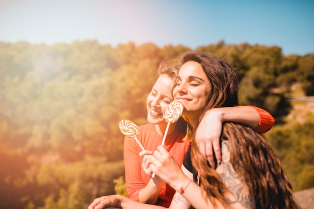 Frauen mit leckeren Lollipops umarmen