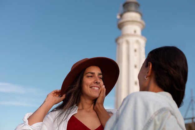 Frauen mit mittlerem Schuss posieren mit Leuchtturm