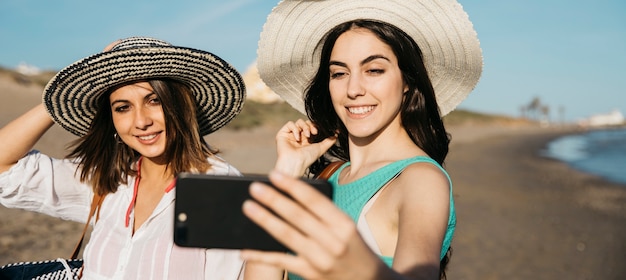 Frauen nehmen Selfie am Strand