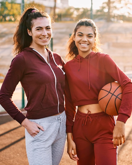 Frauen posieren mit Basketball