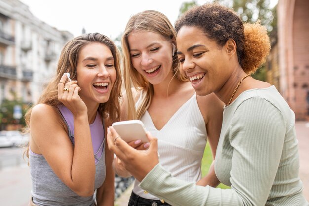 Frauen schauen sich ein Video auf dem Handy an und lachen