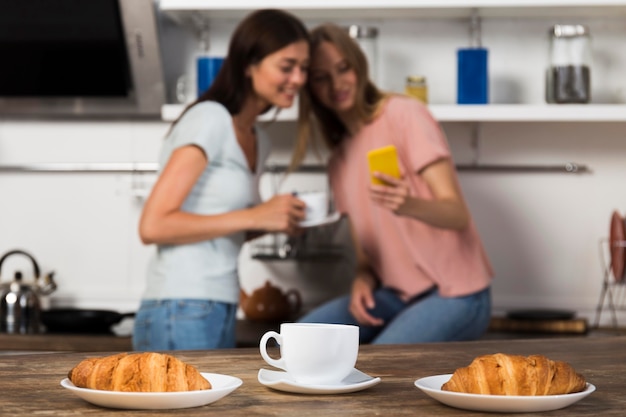 Kostenloses Foto frauen verbringen zeit zusammen zu hause mit kaffee und croissants