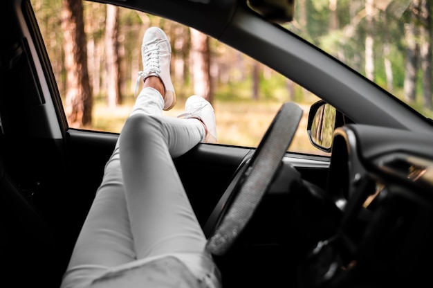 Frauenbeine aus Autofenster heraus