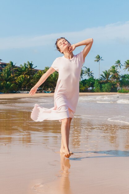 Frauenbeine, die auf dem Strandsand gehen