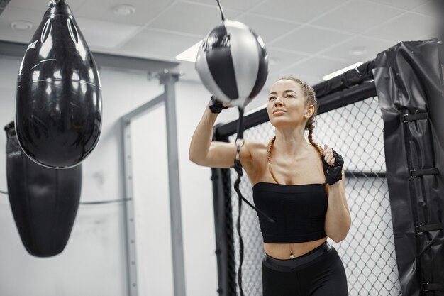 Frauenboxen. Anfänger im Fitnessstudio. Dame in schwarzer Sportbekleidung.