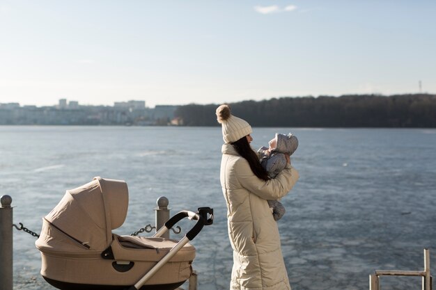 Frauenfrau mit Schätzchen auf Winterseeseite