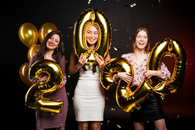 Frauengruppe an den neuen Jahren Parteiholdingballonen