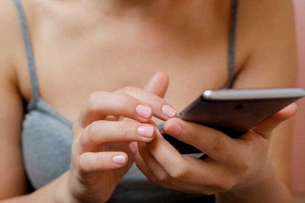 Frauenhände mit Telefon in Händen