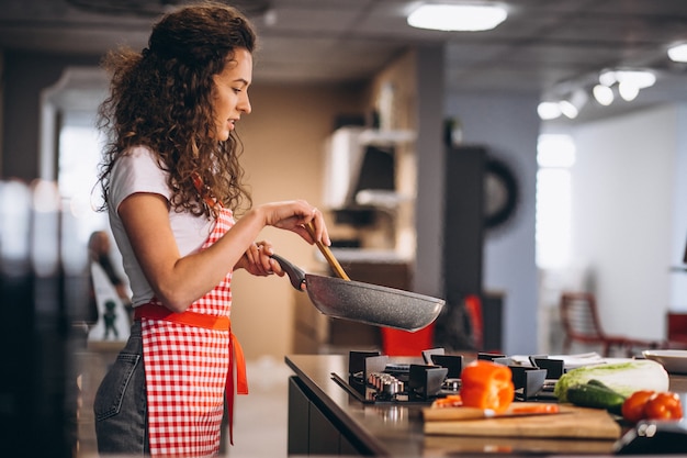 Frauenkoch, der Gemüse in der Pfanne kocht