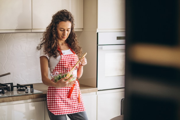 Frauenkoch, der Salat an der Küche macht