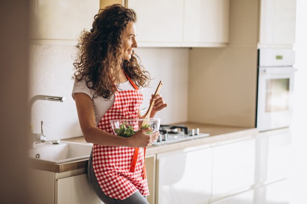 Frauenkoch, der Salat an der Küche macht
