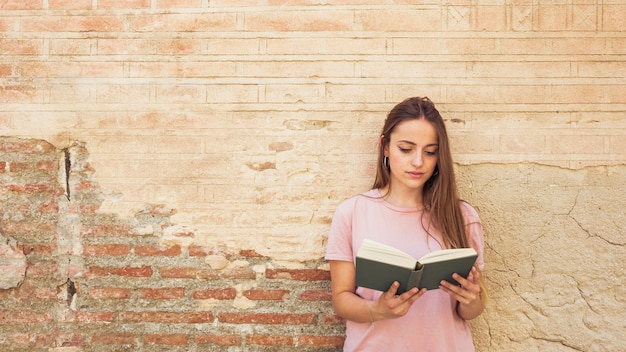 Frauenlesebuch gegen verwitterte Wand