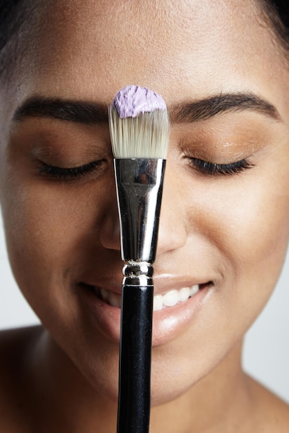 Frauenporträt mit einem Pinsel mit einer violetten Creme darauf