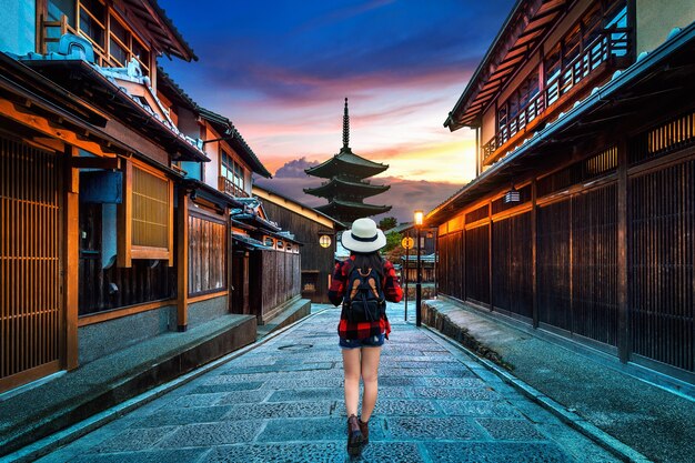 Frauenreisender mit Rucksack, der an Yasaka-Pagode und Sannen-Zaka-Straße in Kyoto, Japan geht.