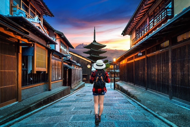 Frauenreisender mit Rucksack, der an Yasaka-Pagode und Sannen-Zaka-Straße in Kyoto, Japan geht.