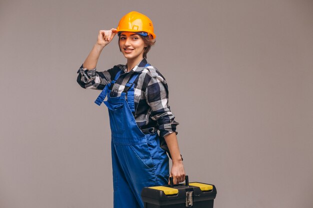 Frauenreparaturbetrieb in der Uniform mit Werkzeugkasten