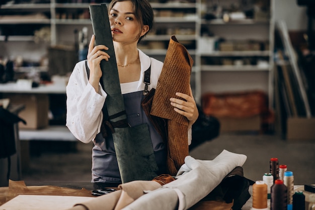 Kostenloses Foto frauenschneider, der an lederstoff arbeitet