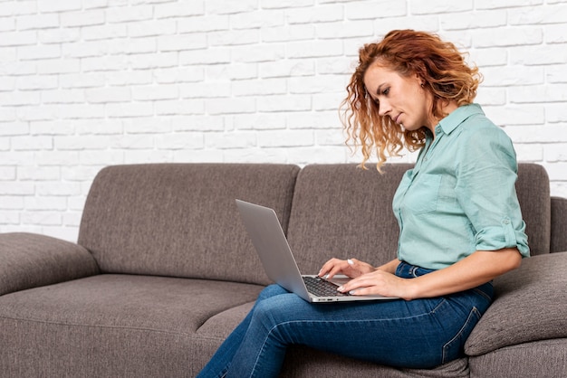 Frauensitzen bei der Prüfung des Laptops