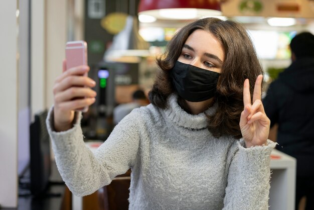 Frauenvideoanruf beim Tragen der medizinischen Maske