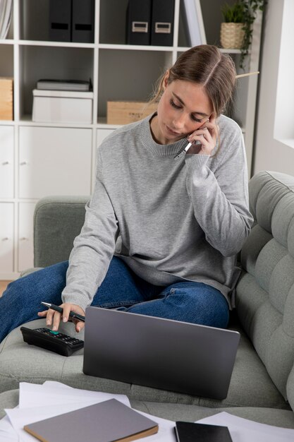 Freiberufler mit mittlerer Einstellung, der auf der Couch arbeitet