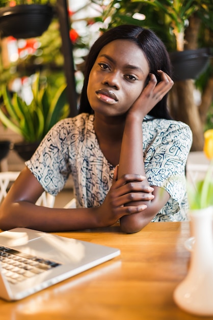 Freiberuflerin der Afroamerikaner mit Laptop in einem Café