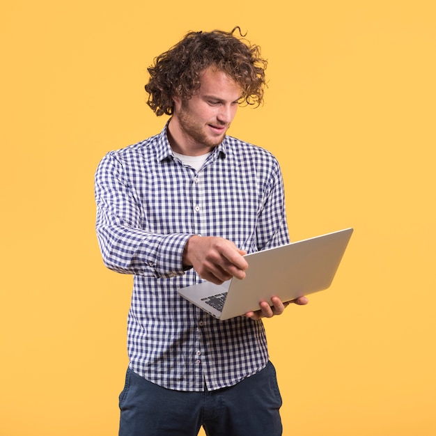 Freiberuflich tätiges Konzept mit dem stehenden Mann, der Laptop verwendet