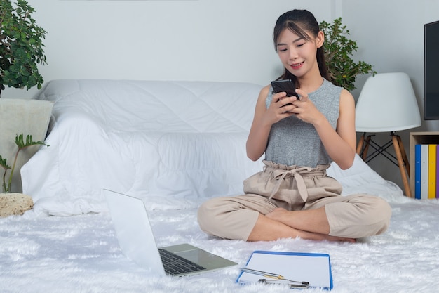 Freiberuflich von zu hause aus arbeiten - junge frau telefoniert im wohnzimmer.